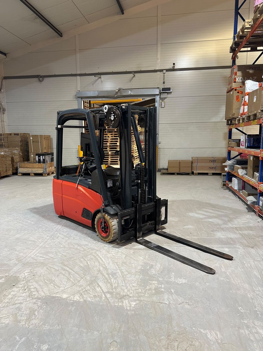 Autonome heftruck voor een koelceldeur, tussen pallets en stellingen